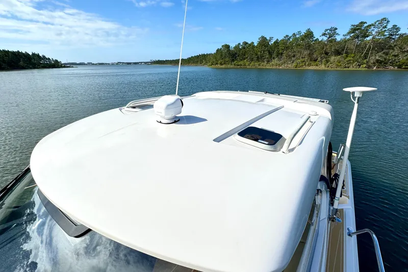 Slide: The Image of 2016 Pursuit OS 325 Offshore boat cruising on a serene lake under a clear blue sky. - 29