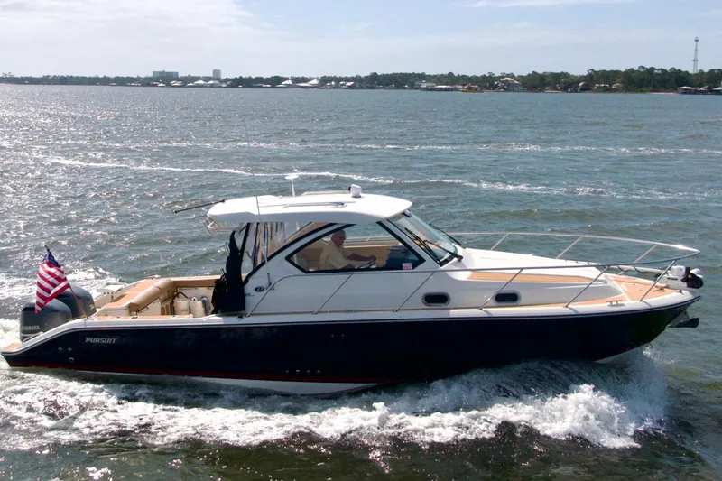 Slide: The Image of 2016 Pursuit OS 325 Offshore boat cruising on open water with American flag. - 3