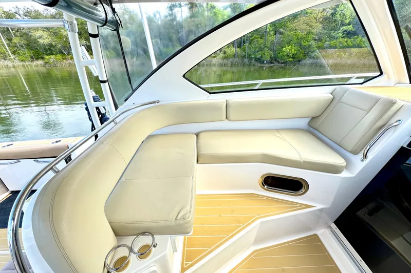 Slide: The Image of 2016 Pursuit OS 325 Offshore boat interior with beige seating and scenic water view. - 32