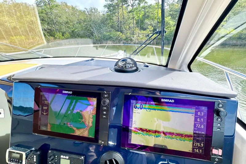Slide: The Image of 2016 Pursuit OS 325 Offshore boat dashboard with Simrad navigation displays. - 36