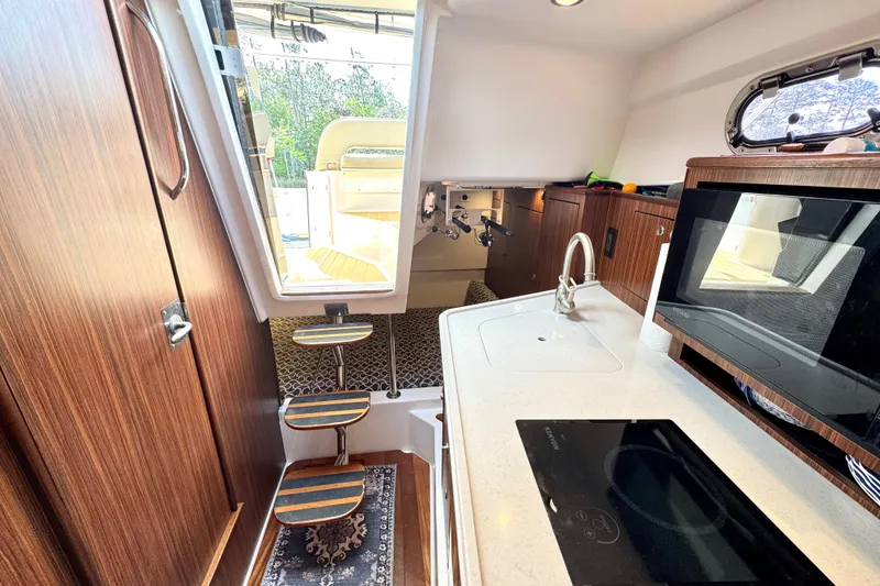 Slide: The Image of Interior of 2016 Pursuit OS 325 Offshore boat with kitchenette and steps to deck. - 39