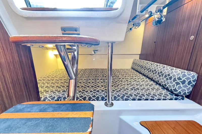 Slide: The Image of 2016 Pursuit OS 325 Offshore cabin interior with patterned cushions and wooden accents. - 40