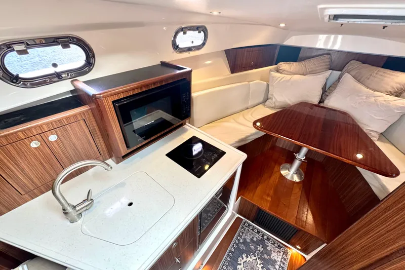 Slide: The Image of Luxurious interior of 2016 Pursuit OS 325 Offshore boat with kitchenette and seating area. - 42