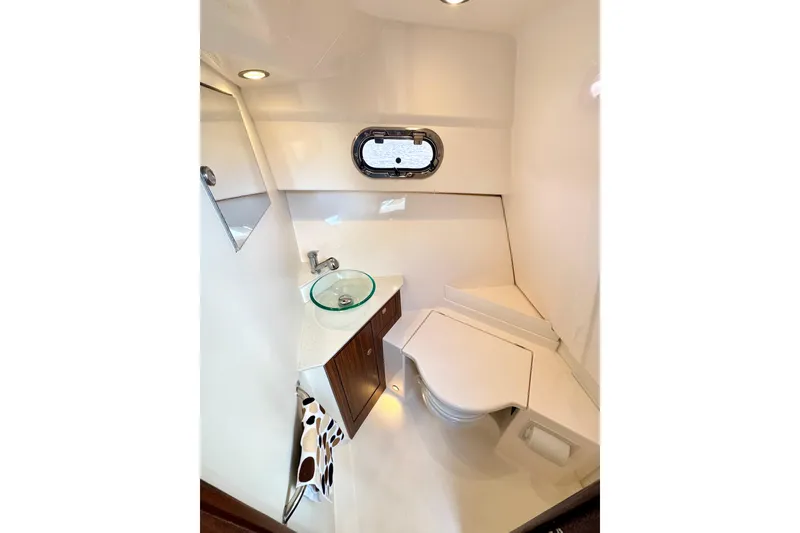 Slide: The Image of 2016 Pursuit OS 325 Offshore boat bathroom with modern sink and compact toilet. - 46