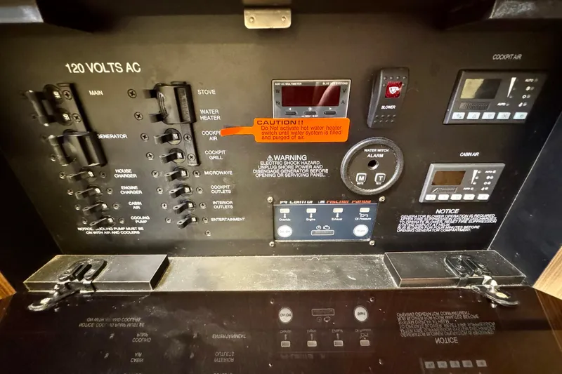 Slide: The Image of Control panel of a 2016 Pursuit OS 325 Offshore boat with various switches and warnings. - 50