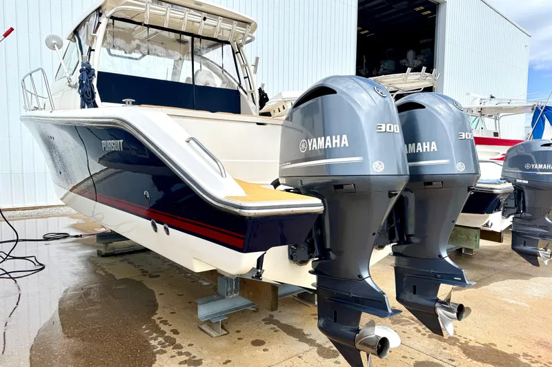 Slide: The Image of 2016 Pursuit OS 325 Offshore boat with twin Yamaha 300 engines in a marina setting. - 51
