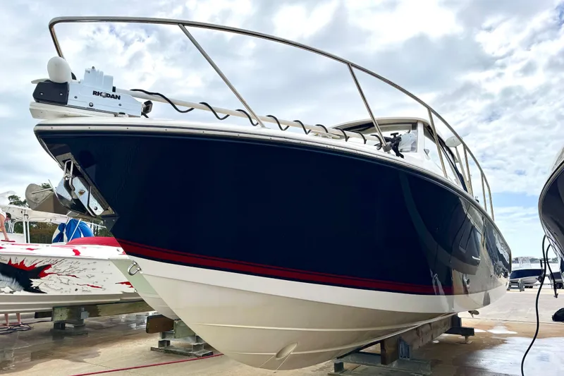 Slide: The Image of 2016 Pursuit OS 325 Offshore boat displayed on a dock under a cloudy sky. - 57
