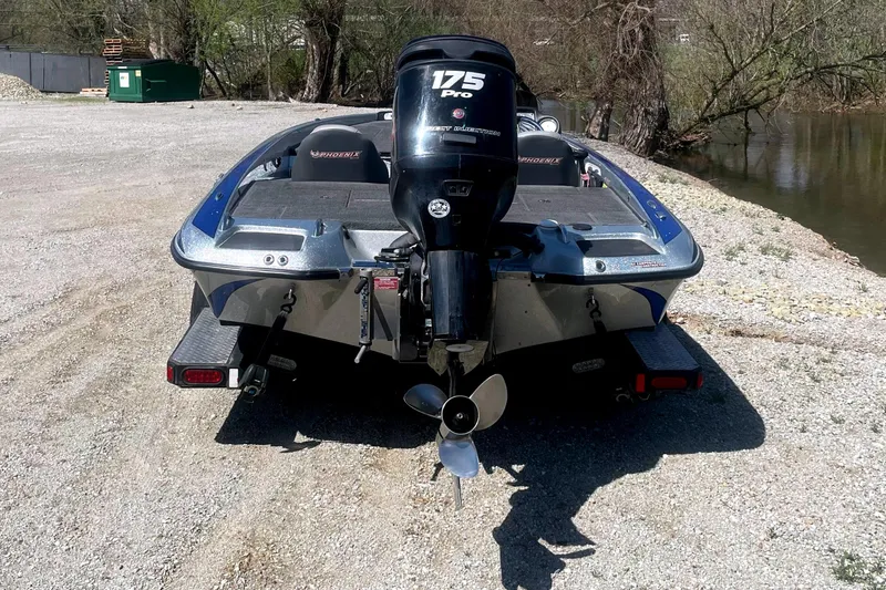 Slide: The Image of 2013 Phoenix 618 Pro boat with 175 HP engine near a serene lakeside. - 5