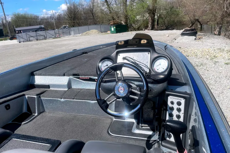 Slide: The Image of 2013 Phoenix 618 Pro boat dashboard with steering wheel and gauges in outdoor setting. - 7