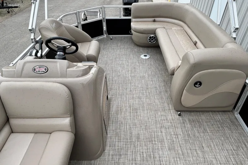 Slide: The Image of Luxurious interior of 2025 Ranger 200C pontoon boat with beige seating and steering console. - 8