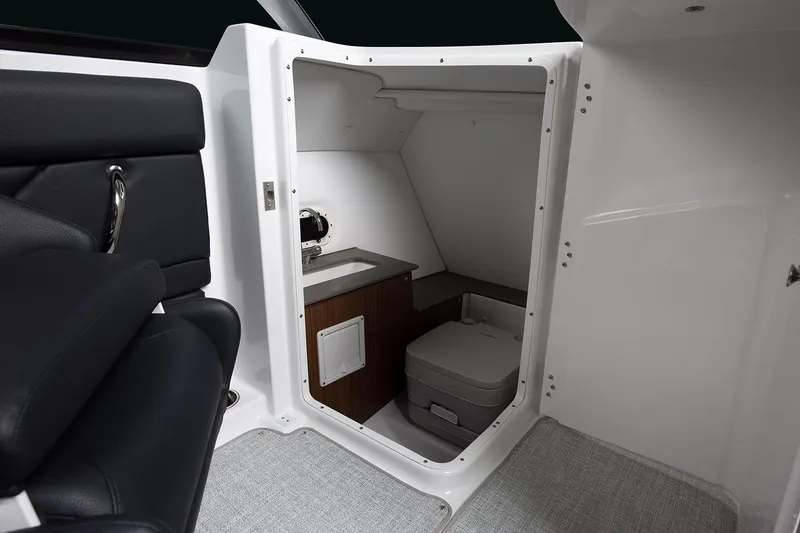 Slide: The Image of Manufacturer Provided Image: 2025 Four Winns HD5 boat interior with compact bathroom and seating area. - 10