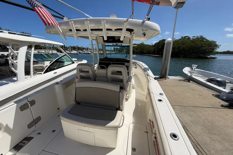 Slide: The Image of 2019 Boston Whaler 330 Outrage docked, showcasing spacious seating and sleek design. - 10