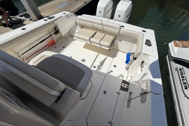 Slide: The Image of 2019 Boston Whaler 330 Outrage boat interior with seating and twin engines. - 12