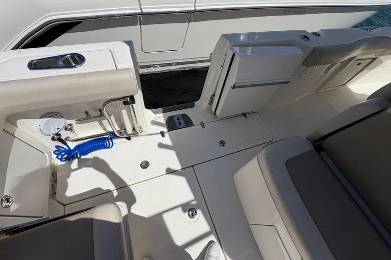 Slide: The Image of 2019 Boston Whaler 330 Outrage deck with seating, storage, and coiled hose. - 14