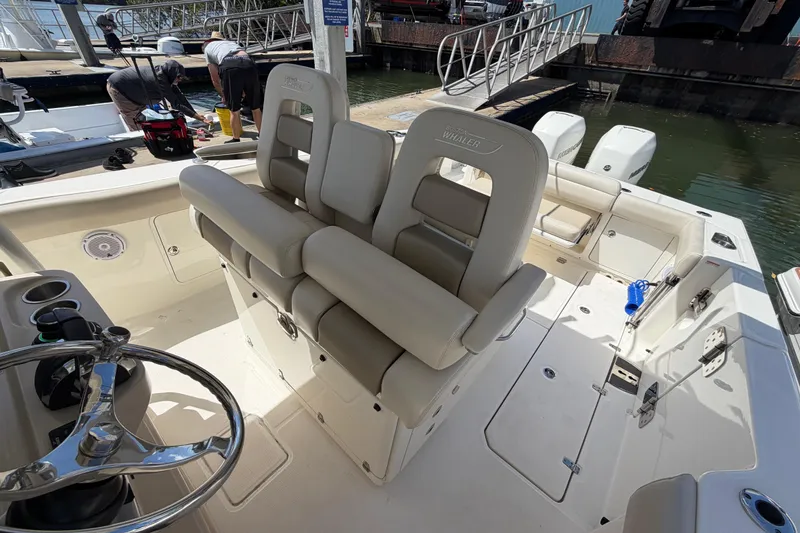 Slide: The Image of 2019 Boston Whaler 330 Outrage boat interior with helm and seating area. - 17