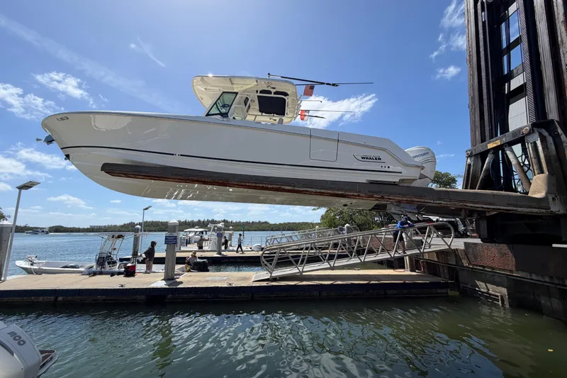 Slide: The Image of 2019 Boston Whaler 330 Outrage boat lifted at marina dockside. - 2