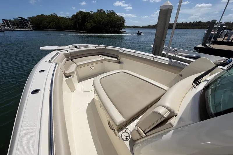 Slide: The Image of 2019 Boston Whaler 330 Outrage boat with spacious seating, docked by a scenic waterway. - 25