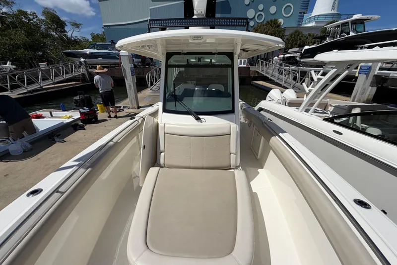 Slide: The Image of 2019 Boston Whaler 330 Outrage boat docked, showcasing spacious seating and sleek design. - 26