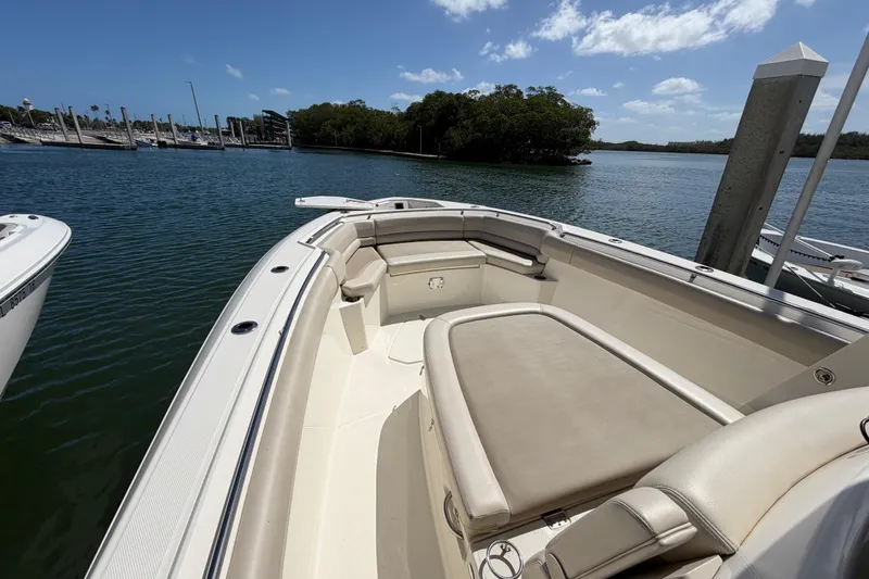 Slide: The Image of 2019 Boston Whaler 330 Outrage boat docked on calm water under a clear sky. - 27