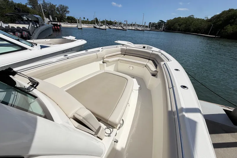 Slide: The Image of 2019 Boston Whaler 330 Outrage boat docked, featuring spacious seating and sleek design. - 28