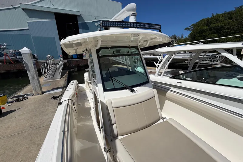 Slide: The Image of 2019 Boston Whaler 330 Outrage docked, showcasing sleek design and spacious seating. - 29