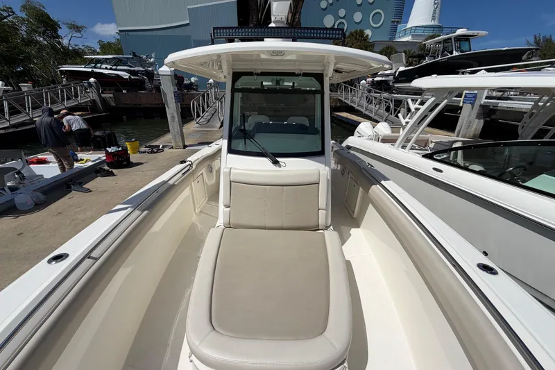 Slide: The Image of 2019 Boston Whaler 330 Outrage boat docked at marina, showcasing spacious seating area. - 32