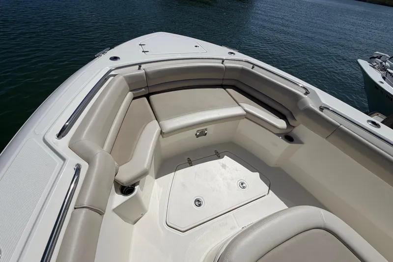 Slide: The Image of 2019 Boston Whaler 330 Outrage boat interior with cushioned seating and storage compartments. - 33