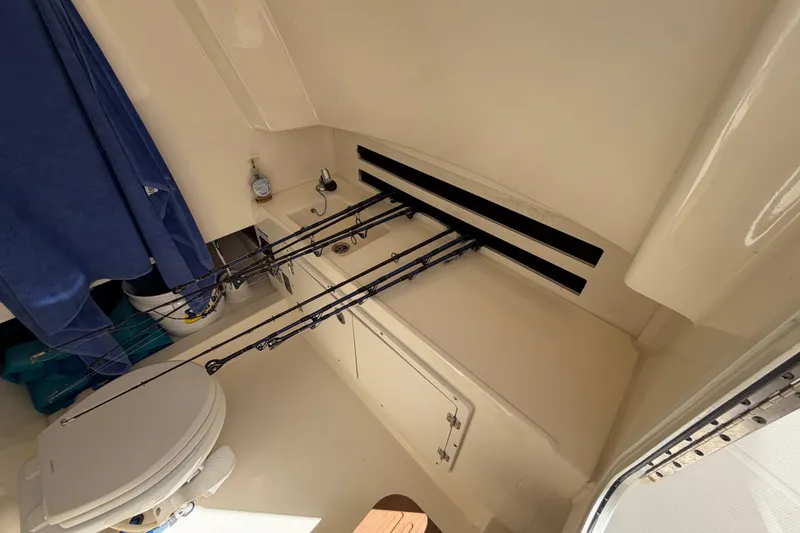 Slide: The Image of Interior of a 2019 Boston Whaler 330 Outrage with fishing rods and toilet. - 34