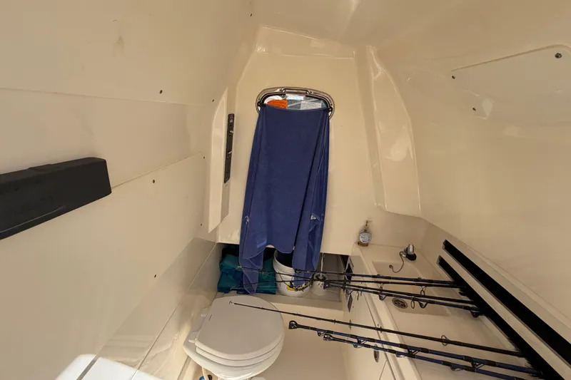 Slide: The Image of Interior cabin of 2019 Boston Whaler 330 Outrage with fishing rods and toilet. - 35