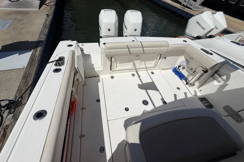 Slide: The Image of 2019 Boston Whaler 330 Outrage boat deck with twin engines and seating area. - 7