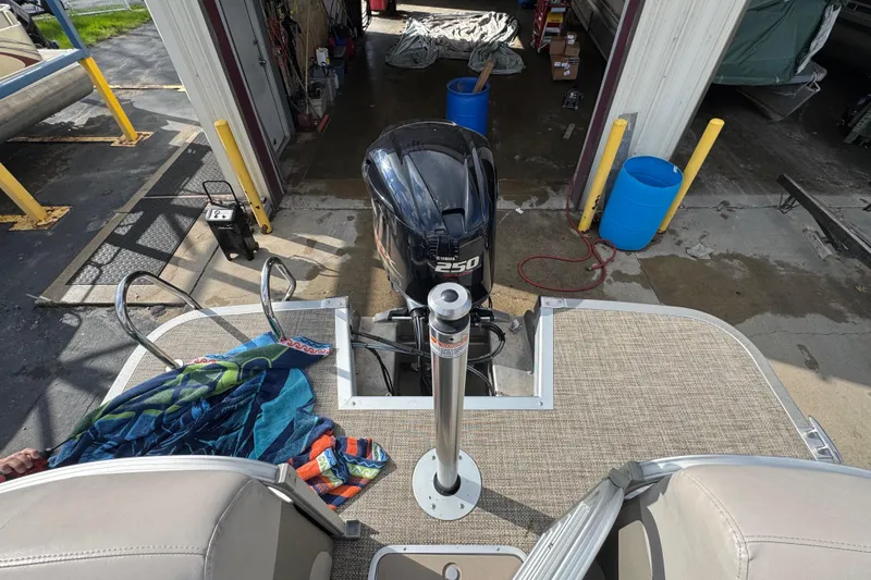 Slide: The Image of 2014 Bennington 2550GSRB pontoon boat with 250 horsepower engine in a maintenance area. - 15