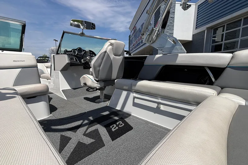 Slide: The Image of 2017 MasterCraft XT23 boat interior with sleek seating and modern dashboard design. - 12