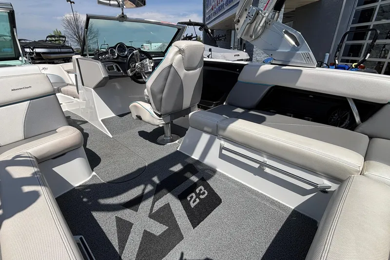 Slide: The Image of Interior of a 2017 MasterCraft XT23 boat, featuring sleek seating and modern dashboard. - 13