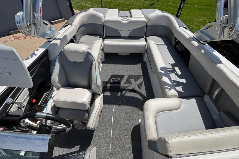 Slide: The Image of 2017 MasterCraft XT23 boat interior with gray seating and steering wheel. - 17