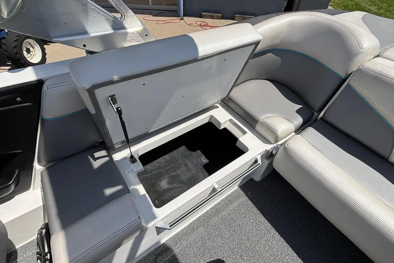 Slide: The Image of 2017 MasterCraft XT23 boat interior with open storage compartment and cushioned seating. - 20