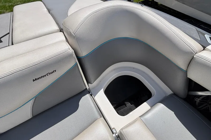 Slide: The Image of 2017 MasterCraft XT23 boat interior with gray seating and storage compartment. - 24