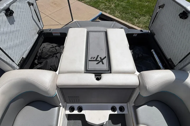 Slide: The Image of 2017 MasterCraft XT23 boat interior with open storage compartments and seating. - 29