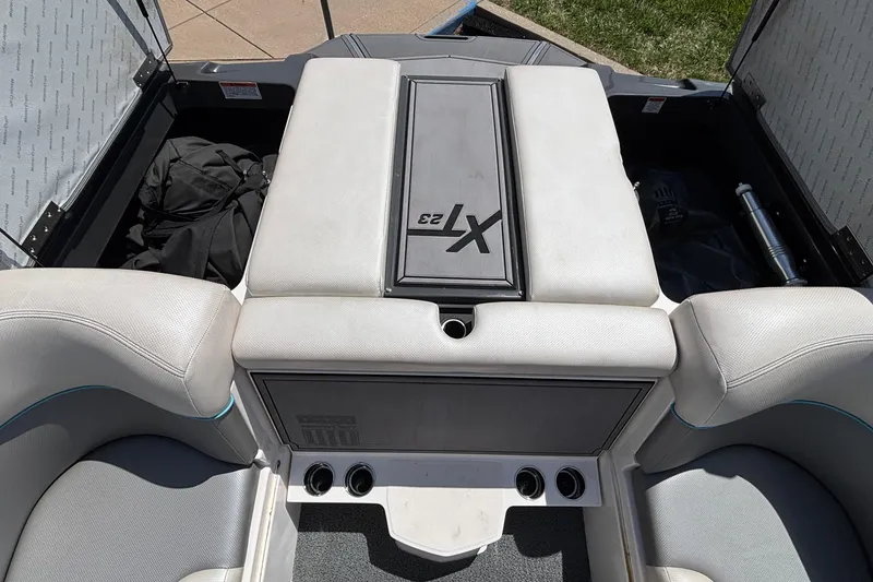 Slide: The Image of 2017 MasterCraft XT23 boat interior with storage compartments open, showcasing seating and design. - 30