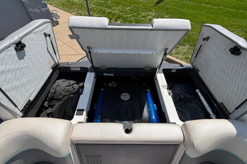 Slide: The Image of Open engine compartment of a 2017 MasterCraft XT23 boat, showing storage and engine components. - 31