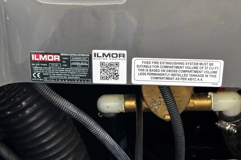 Slide: The Image of 2017 MasterCraft XT23 engine compartment with Ilmor emission control labels and fire extinguisher instructions. - 33