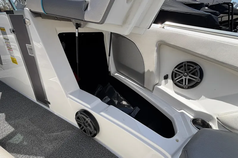 Slide: The Image of 2017 MasterCraft XT23 boat interior storage compartment with speaker and cup holder. - 47