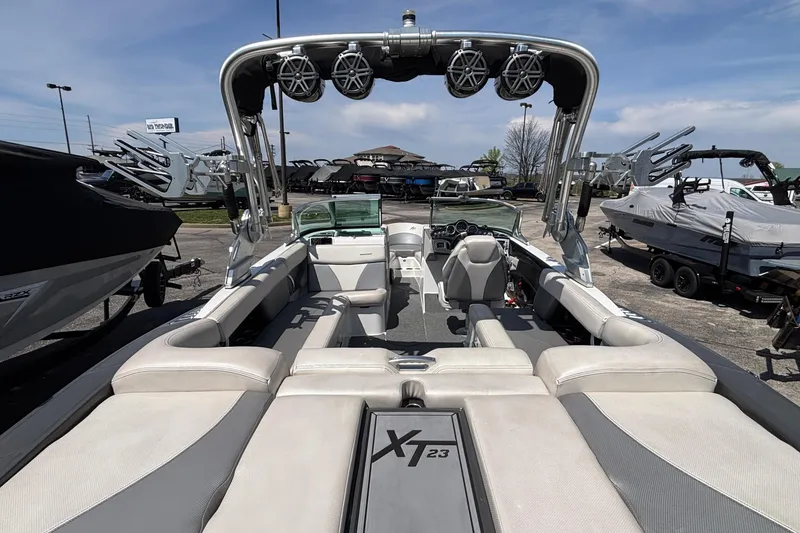 Slide: The Image of 2017 MasterCraft XT23 boat interior with seating and speakers, displayed outdoors. - 5