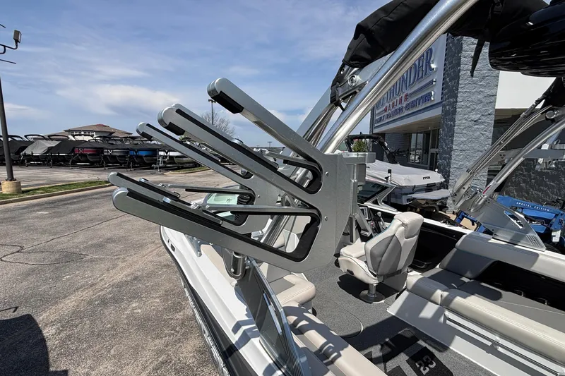 Slide: The Image of 2017 MasterCraft XT23 boat with wakeboard rack, parked at a marina under clear skies. - 57