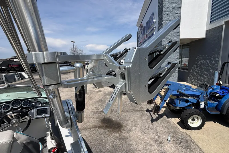 Slide: The Image of 2017 MasterCraft XT23 boat with wakeboard rack and dashboard, parked near dealership. - 58