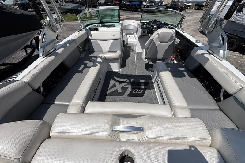 Slide: The Image of 2017 MasterCraft XT23 boat interior with gray seating and modern dashboard. - 6