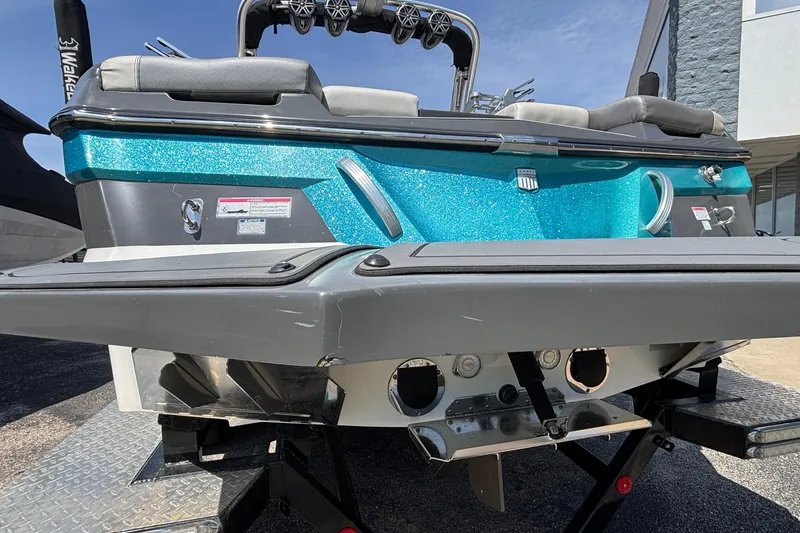 Slide: The Image of 2017 MasterCraft XT23 boat rear view with blue glitter finish and seating. - 65