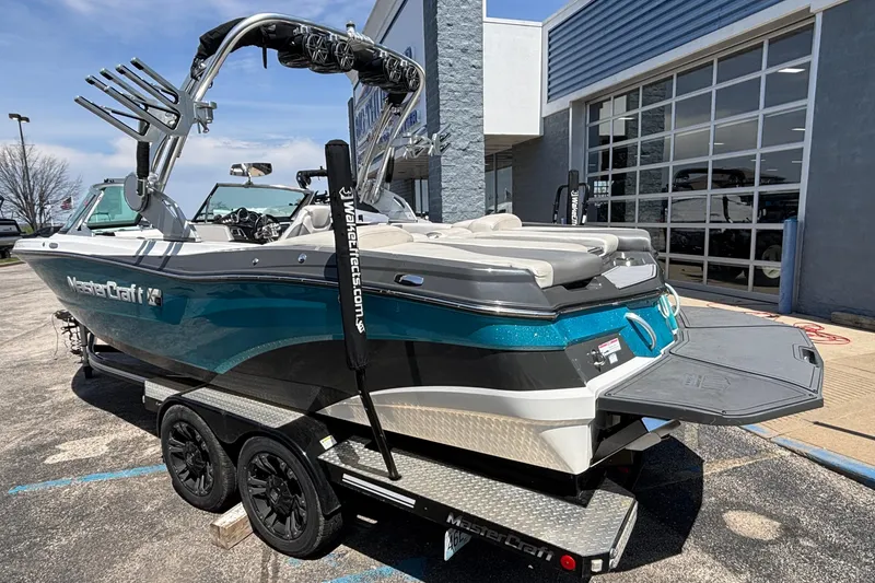 Slide: The Image of 2017 MasterCraft XT23 boat on trailer, parked outside a building, showcasing sleek design. - 68