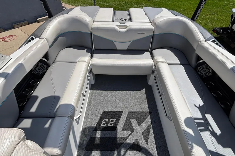 Slide: The Image of 2017 MasterCraft XT23 boat interior with gray seating and carpeted flooring. - 7
