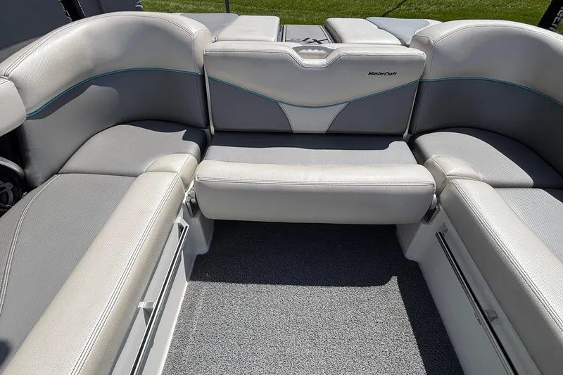 Slide: The Image of 2017 MasterCraft XT23 boat interior with gray seating and blue accents. - 9