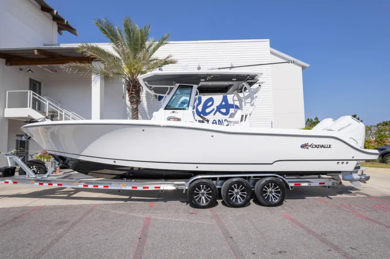 Slide: The Image of 2026 Crevalle 33 CSF boat on trailer, parked outdoors near a building. - 14